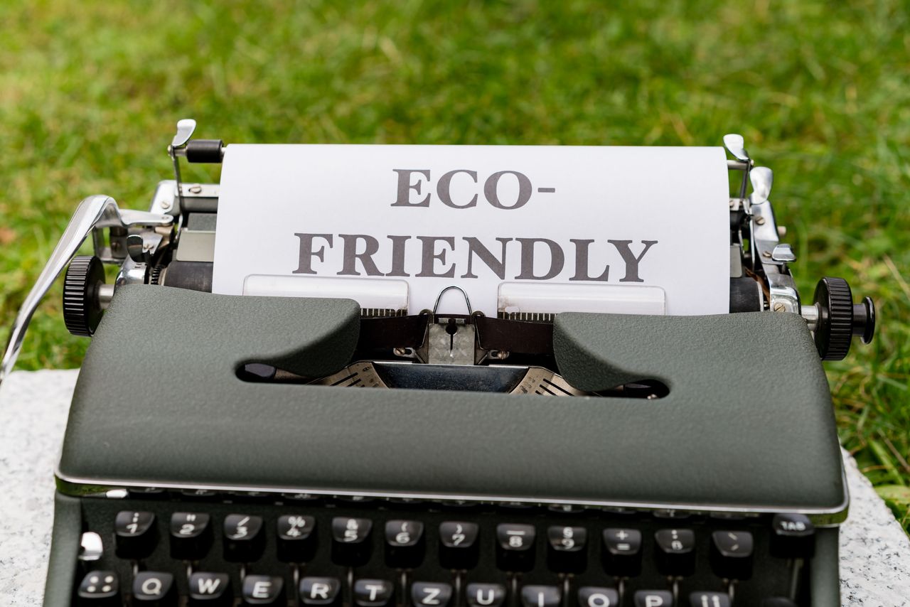 about-us A vintage typewriter displays an eco-friendly message outdoors on grass.