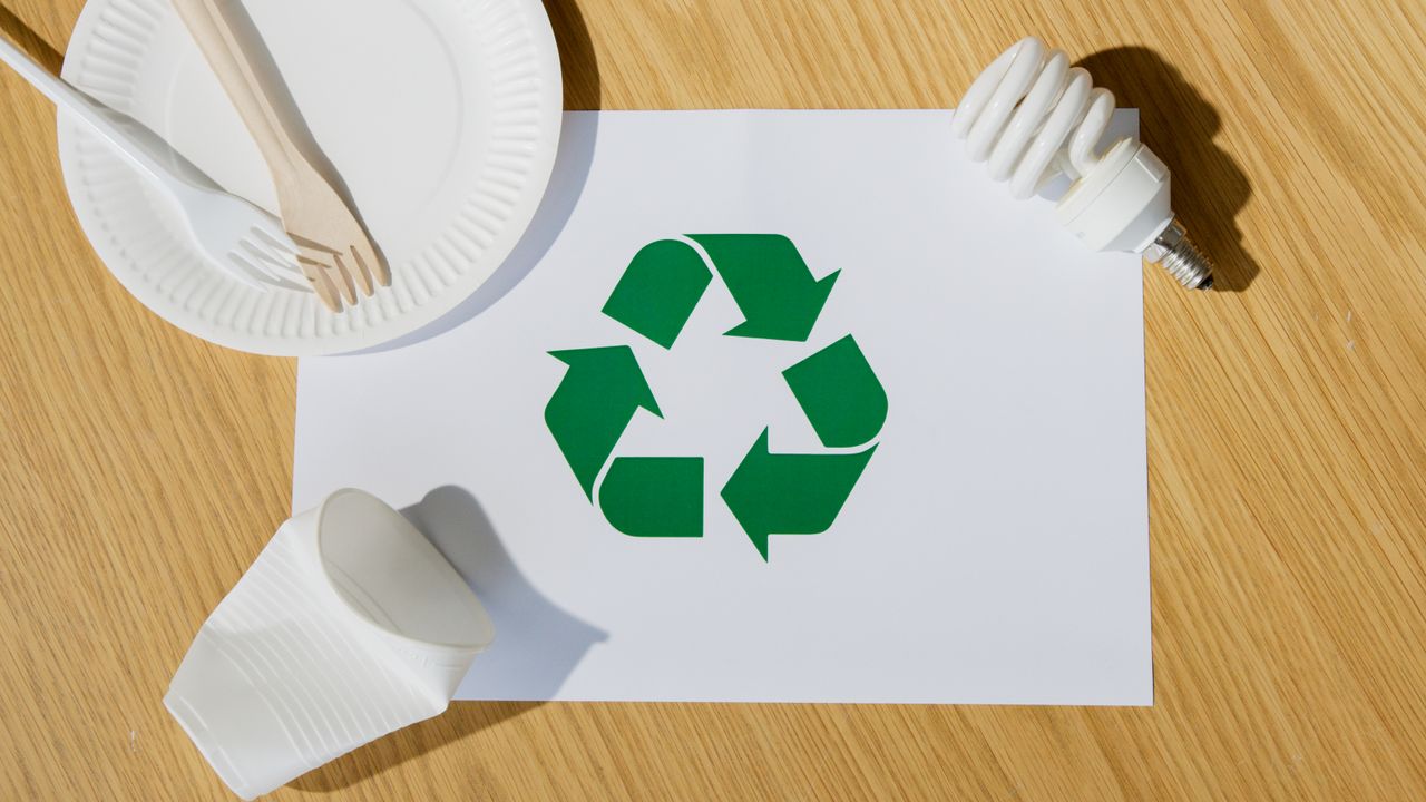 services-04 Eco-friendly utensils, light bulb, and recycling symbol on paper emphasize sustainable living.
